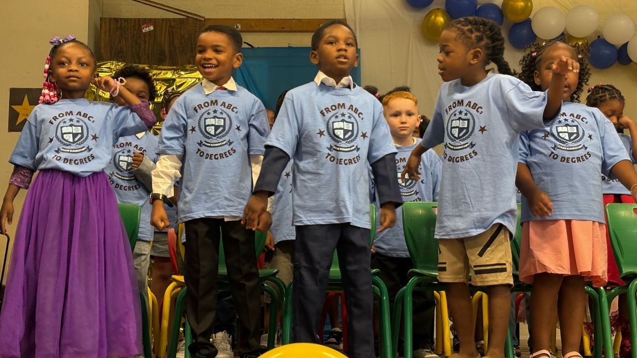 A group of young students wearing light blue t-shirts that read 