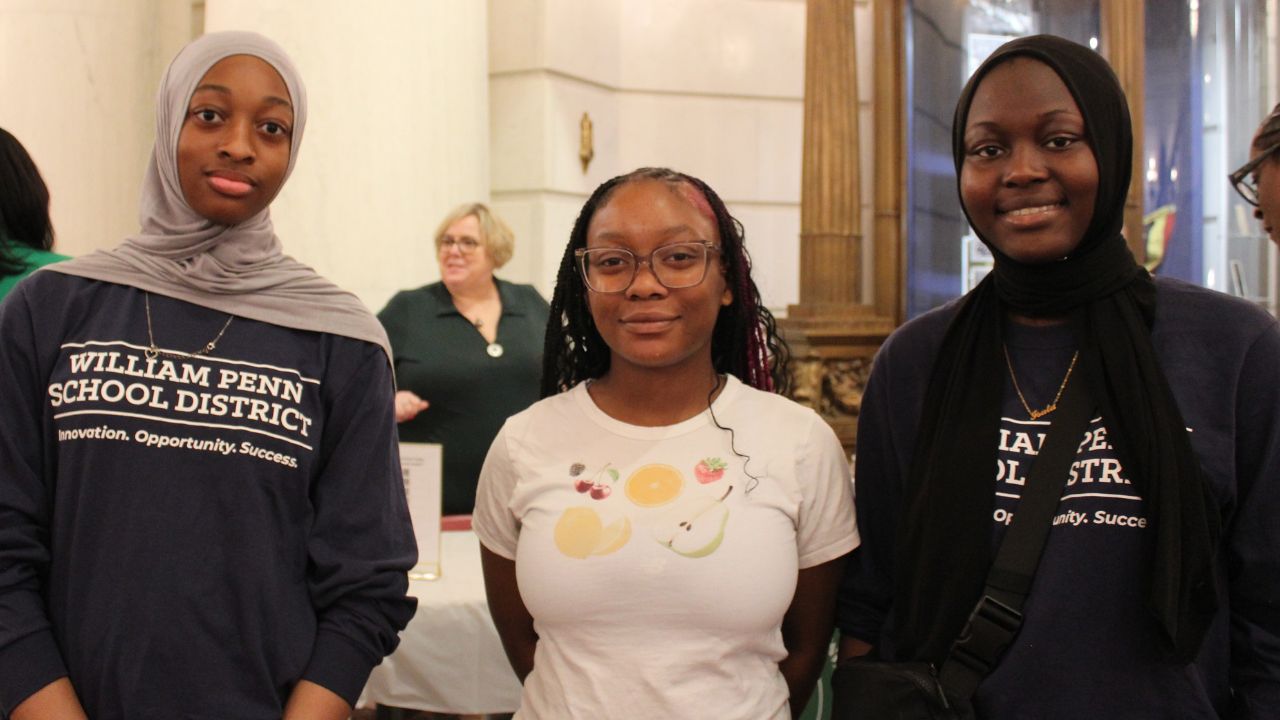 3 students smilling. One wearing a William Penn School District shirt